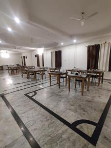ラムナガルにあるHOTEL THE CORBETT VANSHのテーブルと椅子が備わる広い客室です。