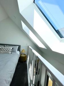 a bedroom with a bed and a staircase with a window at Sunny Oasis- Modern Loft Hidden on Cashel in Christchurch +18 photos