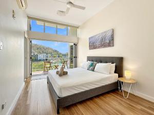 a bedroom with a bed and a large window at Waterfront 'Beachside' Apartment - Ocean View, Central location, Pool, Wifi, King bed, Deluxe Spa Ensuite in Nelly Bay