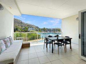 a living room with a table and a couch at Waterfront 'Beachside' Apartment - Ocean View, Central location, Pool, Wifi, King bed, Deluxe Spa Ensuite in Nelly Bay