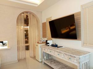 a living room with a television on a wall at Amity Beach Resort in Koh Samui 
