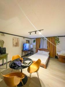 1 dormitorio con 1 cama, mesa y sillas en The Breeze View Lodge - Tagaytay en Ulot