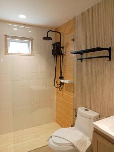 La salle de bains est pourvue d'une douche et de toilettes blanches. dans l'établissement Amity Beach Resort, à Koh Samui 