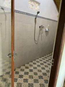 een badkamer met een douche en een tegelvloer bij Sakti OceanView Nusa Penida in Nusa Penida