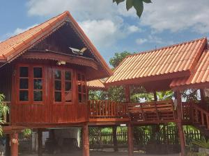 a wooden house with a balcony and a bird on the roof at Duangmanee Homestay in Ban Si Kaeo