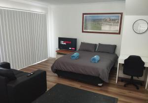 - une chambre avec un lit et une télévision dans l'établissement Ascot Gardens Serviced Apartments, à Dubbo