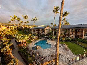 an aerial view of a resort with a pool and palm trees at Oceanfront Penthouse with Loft in Kailua-Kona