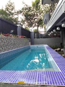 una piscina con azulejos azules en el suelo en Sky Rancho Hostel en Tagaytay