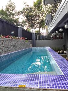 a swimming pool with blue tiles on the ground at Sky Rancho Hostel in Tagaytay