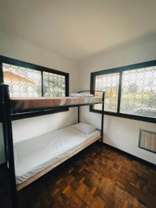 two bunk beds in a room with two windows at Sky Rancho Hostel in Tagaytay