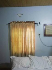 ein Schlafzimmer mit einem Bett und einem Fenster mit einem Vorhang in der Unterkunft Diamond Hotel close to Intl Airport, omole ikeja in Mawere