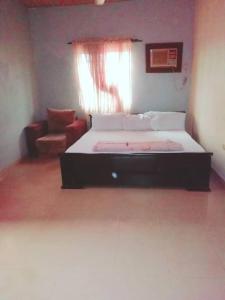 1 dormitorio con cama, sofá y ventana en Diamond Hotel close to Intl Airport, omole ikeja, en Mawere