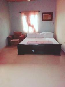 a bedroom with a bed and a couch and a window at Diamond Hotel close to Intl Airport, omole ikeja in Mawere