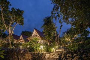 een huis verlicht in de nacht met bomen bij Deep Roots Dive & Yoga Resort in Nusa Penida