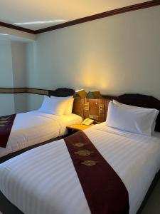 a hotel room with two beds and a phone at Suntara Wellness Resort & Hotel in Chachoengsao