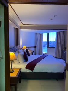 una camera da letto con un grande letto con una grande finestra di Suntara Wellness Resort & Hotel a Chachoengsao