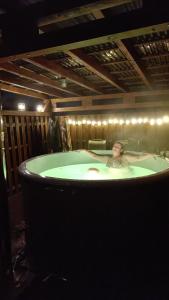 una persona en una bañera en una habitación en Sudecka Ostoja z Balią i Sauną, en Lubawka