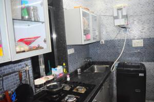 a small kitchen with a sink and a stove at Prince Solo Hostel in Mumbai