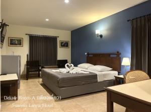 1 dormitorio con cama y pared azul en Suansin Lanna Hotel en Tak