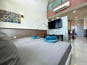 a room with a bed with a tv on the wall at PD 4 Bedrooms Duplex - Full Seaview (Up to 16 Pax) in Port Dickson