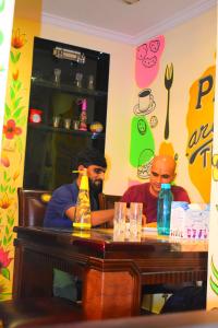 two men sitting at a table in a restaurant at Prince Solo Hostel in Mumbai
