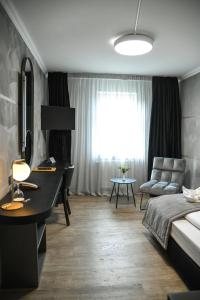 Schlafzimmer mit einem Bett, einem Schreibtisch und einem Fenster in der Unterkunft Hotel Zum Weissen Ross in Delitzsch