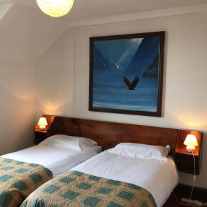 two beds in a hotel room with a bird painting on the wall at The Jericho Hotel in Oxford