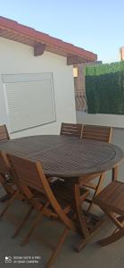 a wooden table and chairs on a patio at Hostel Apart in Dar el Beïda