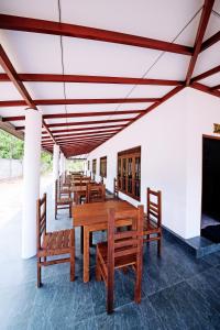 una fila di tavoli e panche in legno in un edificio di Mondial Dream Resort a Wellawaya