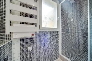 a bathroom with black and white tiles and a glass shower at La Sérénade Numéro 1 in Montreuil +10 photos