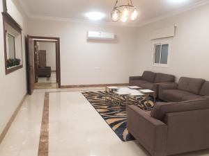 a living room with two couches and a table at مورايا Murraya in Abyār ‘Alī