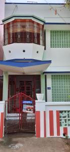 a building with a red and white gate in front of it at Temple Darshan in Chidambaram