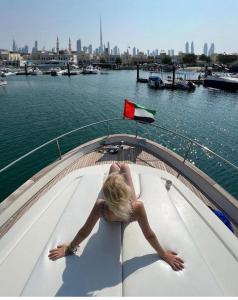 Una donna è seduta su una barca in acqua di Stella Romana Yacht a Dubai