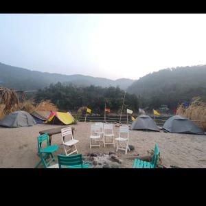 a group of chairs and tents on a beach at Dawki, Frankenstein adventure camp, riverside camping in Dawki