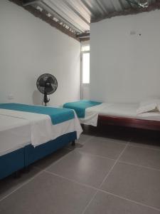 Habitación con 2 camas y ventilador. en Proyecto MOONLIGHT en Villavieja