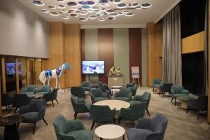 a room with chairs tables and a horse on a screen at The World Surat in Surat