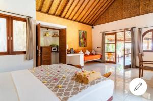 a bedroom with a bed and a living room at Santan Gili Cottages in Gili Trawangan