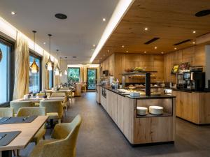 un restaurante con paredes de madera, mesas y sillas en Hotel Andrea en Mayrhofen