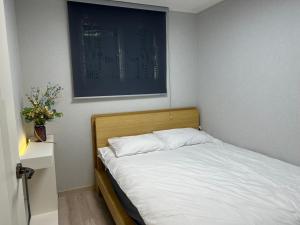 a bed in a bedroom with a picture on the wall at Stay Sheem Nokbeon st 3 min in Seoul