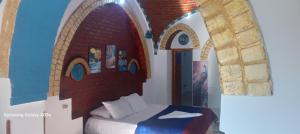 a bedroom with a bed with a brick wall at Golden Palace Garden in Luxor