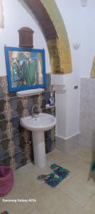 a bathroom with a sink and a painting on the wall at Golden Palace Garden in Luxor