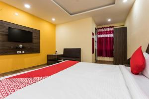 a bedroom with a large bed and a television at Fun and Food Resort & Holidays in Harsola