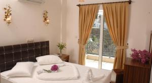 une chambre avec un lit avec des oreillers blancs et une fenêtre dans l'établissement GTH GLORİA GÜMBET HOTEL, à Bodrum City