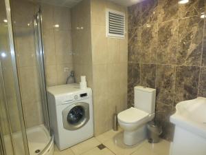 ein Badezimmer mit einem WC und einer Waschmaschine in der Unterkunft Civan Apart in Ankara