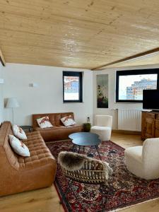 a living room with a couch and a table at Penthouse au cœur de Val Thorens in Val Thorens