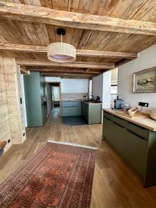 ヴァル・トランスにあるPenthouse au cœur de Val Thorensの木製の天井とラグ付きの広いキッチン