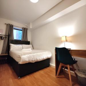 - une chambre avec un lit, un bureau et une chaise dans l'établissement Liverpool City Centre Private Rooms including smart TVs - with Shared Bathroom, à Liverpool