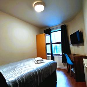 a bedroom with a bed and a desk and a window at Liverpool City Centre Private Rooms including smart TVs - with Shared Bathroom in Liverpool