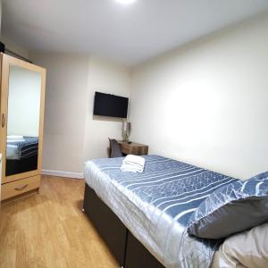 1 dormitorio con 1 cama y TV de pantalla plana en Liverpool City Centre Private Rooms including smart TVs - with Shared Bathroom, en Liverpool
