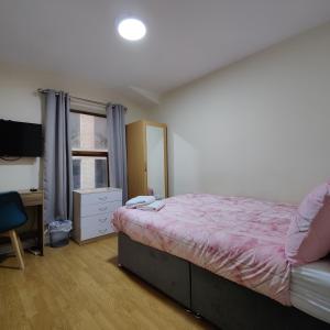 a bedroom with a bed and a desk and a television at Liverpool City Centre Private Rooms including smart TVs - with Shared Bathroom in Liverpool